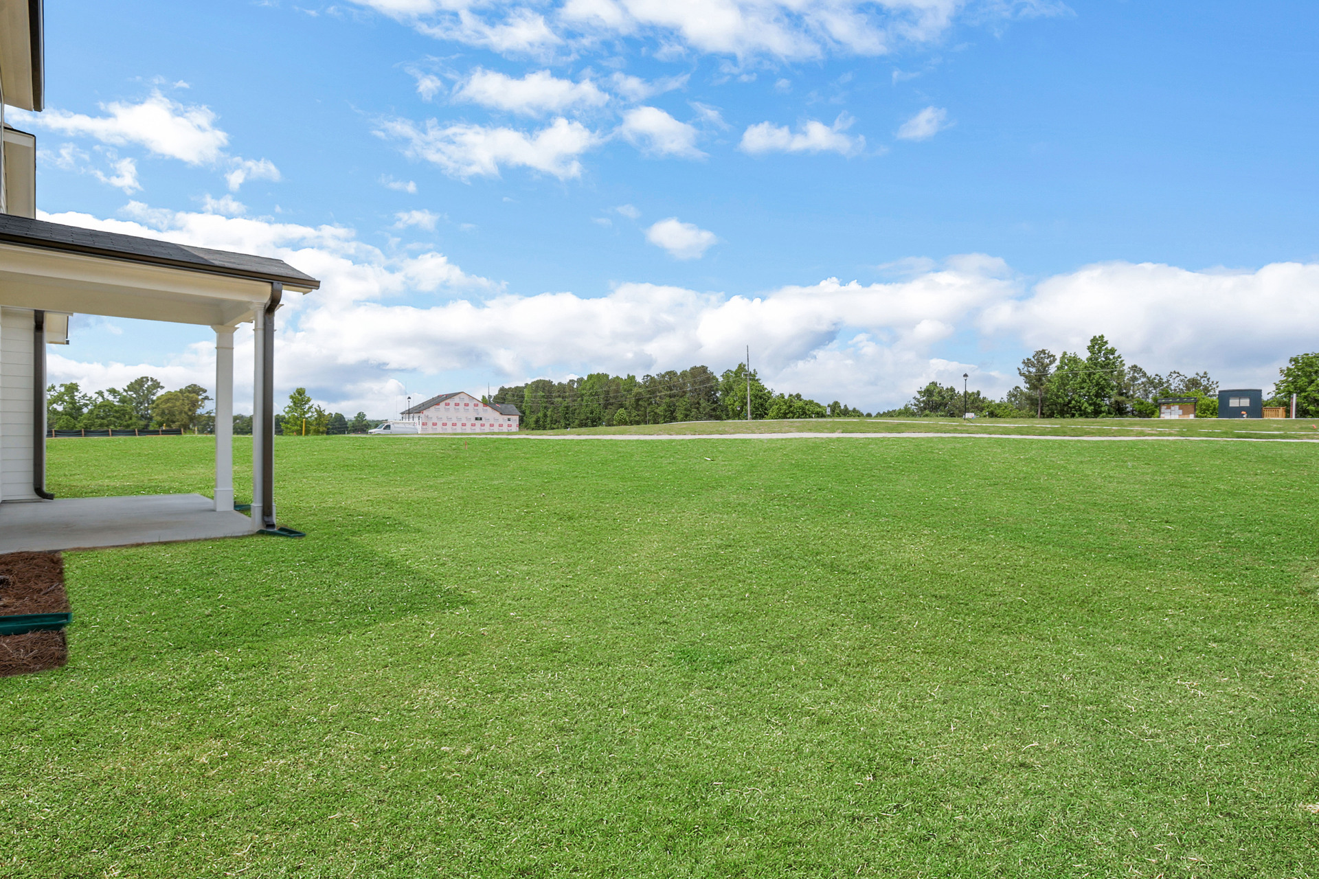 backyard of 2-story home with grass and covered patio