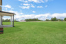 backyard of 2-story home with grass and covered patio