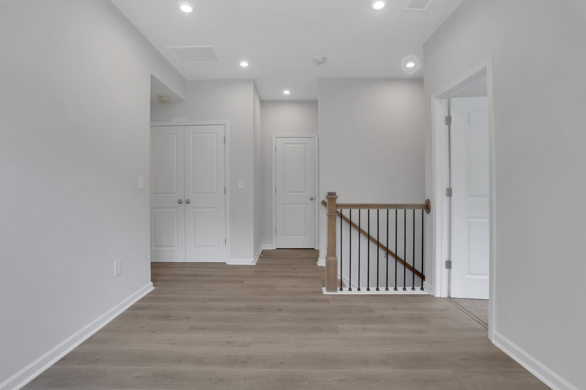 loft with hard-surface flooring and white paint on the walls