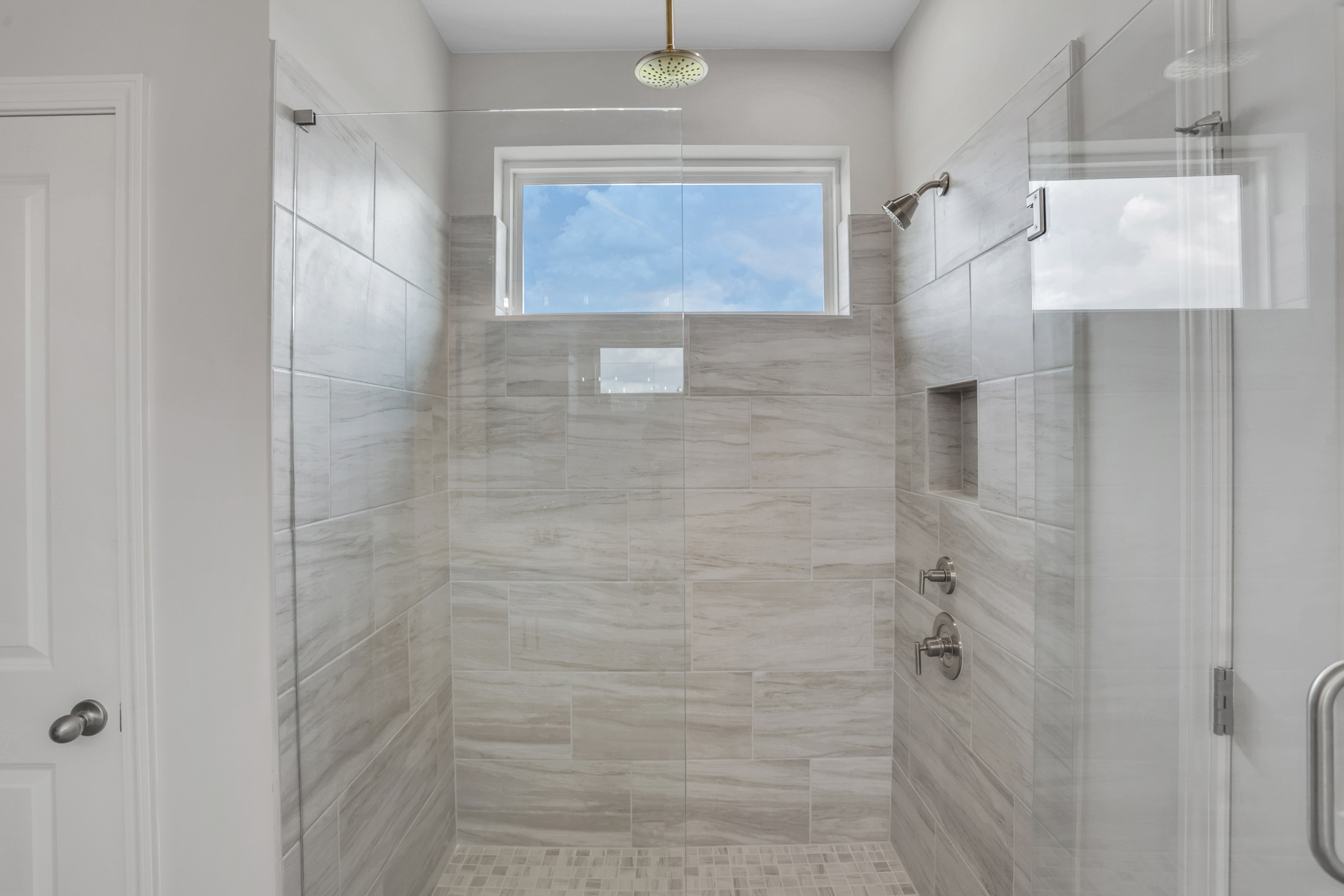 primary bathroom with walk-in shower and tile floors