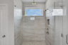 primary bathroom with walk-in shower and tile floors