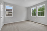 secondary bedroom with carpet and windows