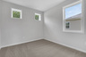 secondary bedroom with carpet and windows