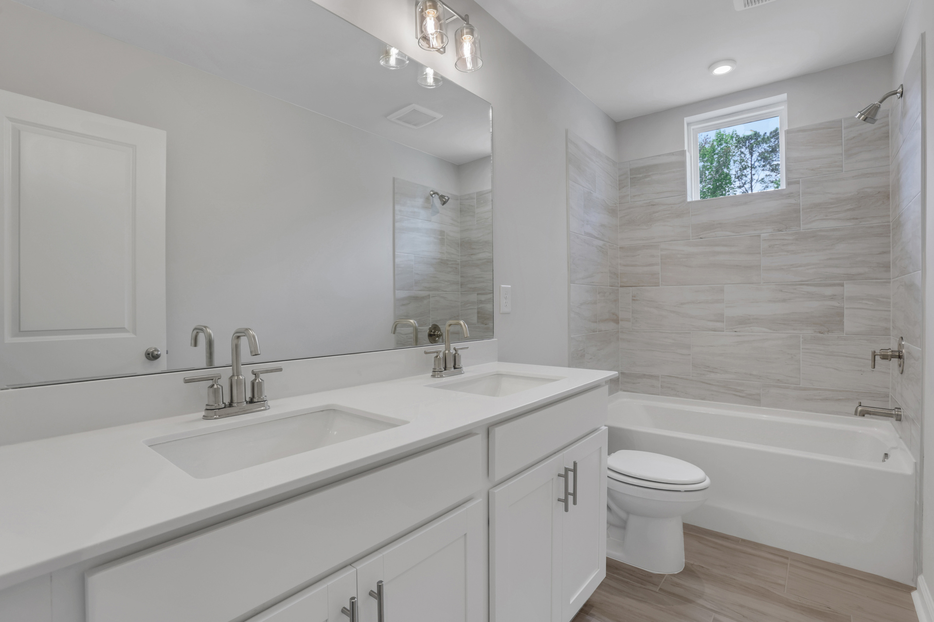 secondary bathroom with dual vanity and shower/tub combo