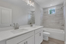 secondary bathroom with dual vanity and shower/tub combo