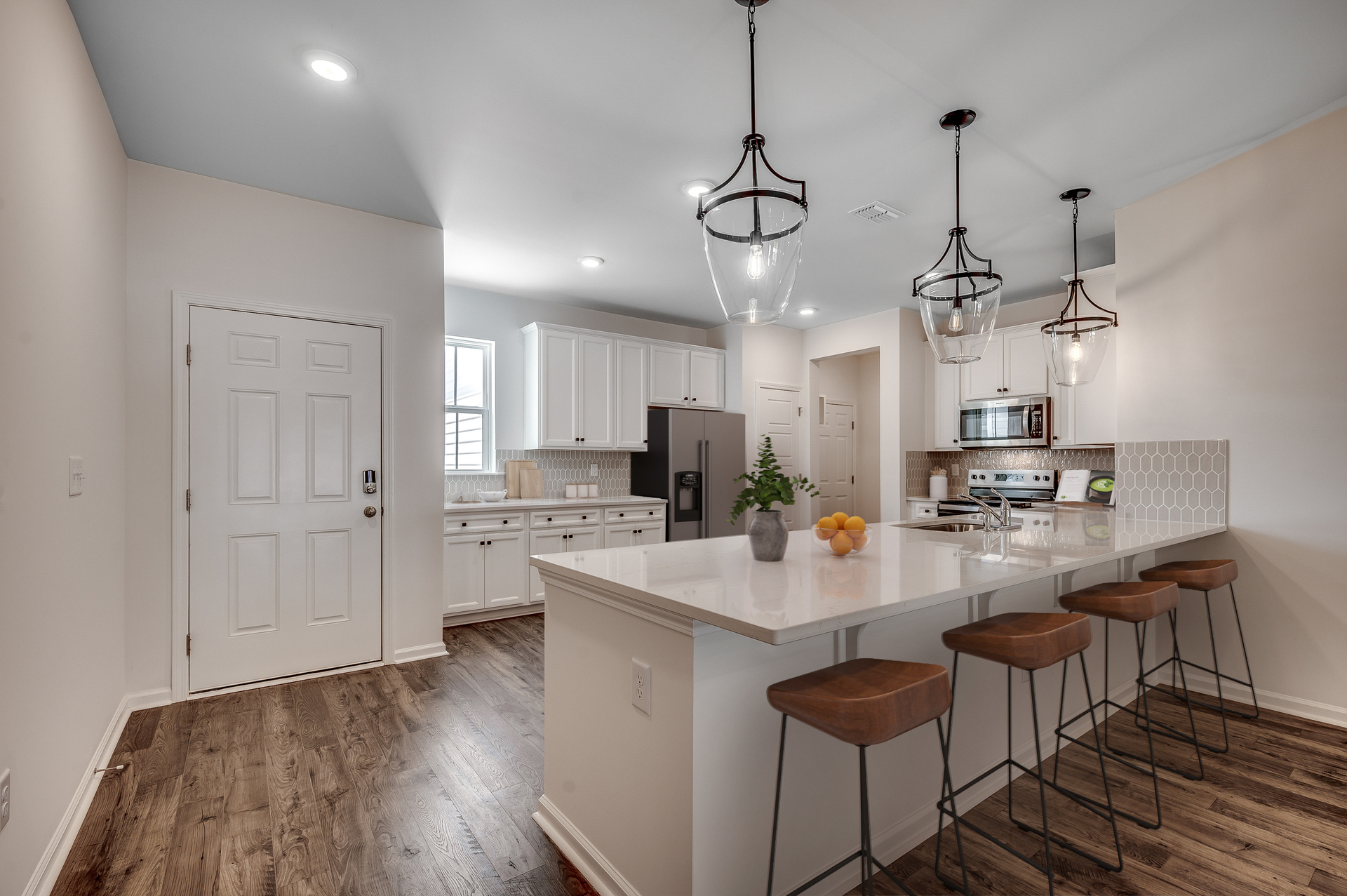 spacious island with bar stools and pendant lighting 