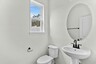 toilet with white sink and mirror and one window