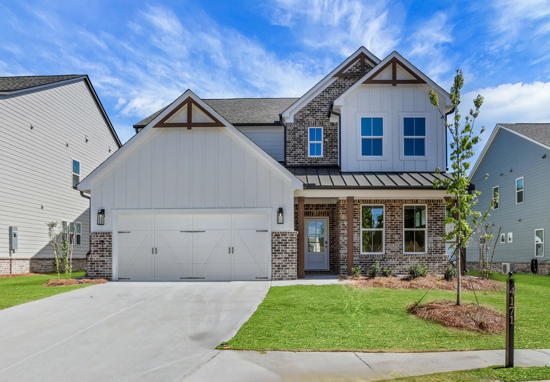 front of 2-story home with light siding and dark brick