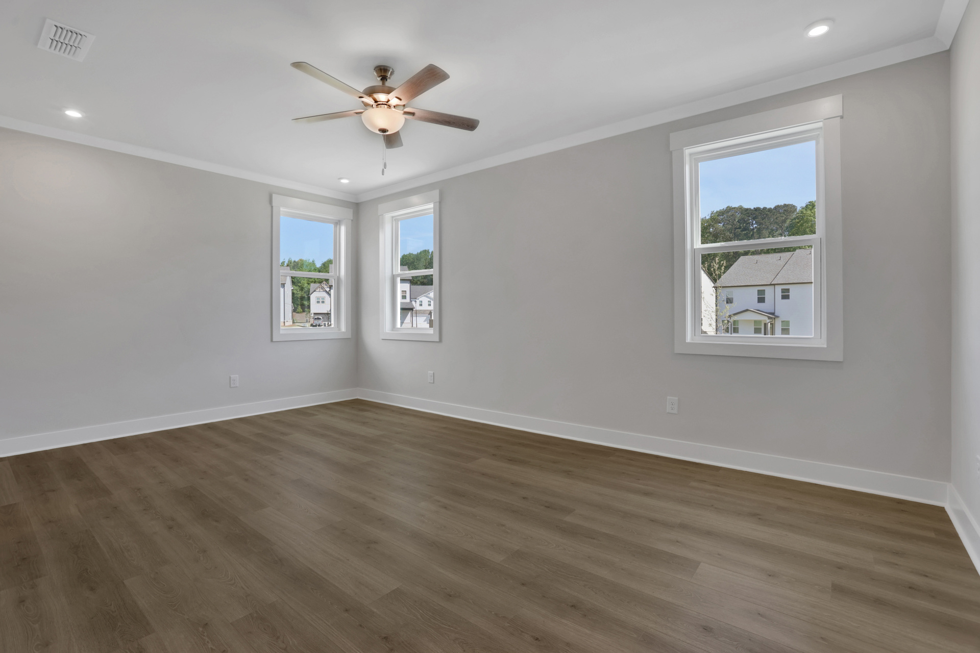 primary bedroom with hard-surface flooring and windows