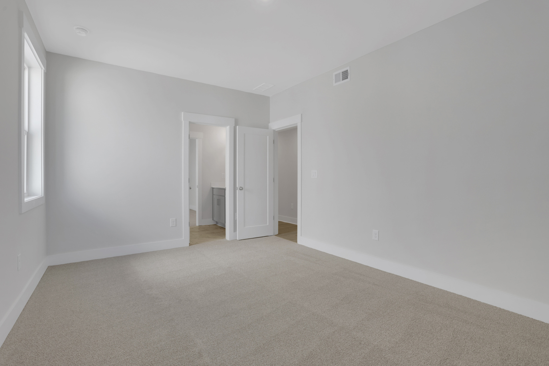 secondary bedroom with carpet and windows