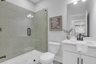 secondary bathroom with white cabinets and tile flooring