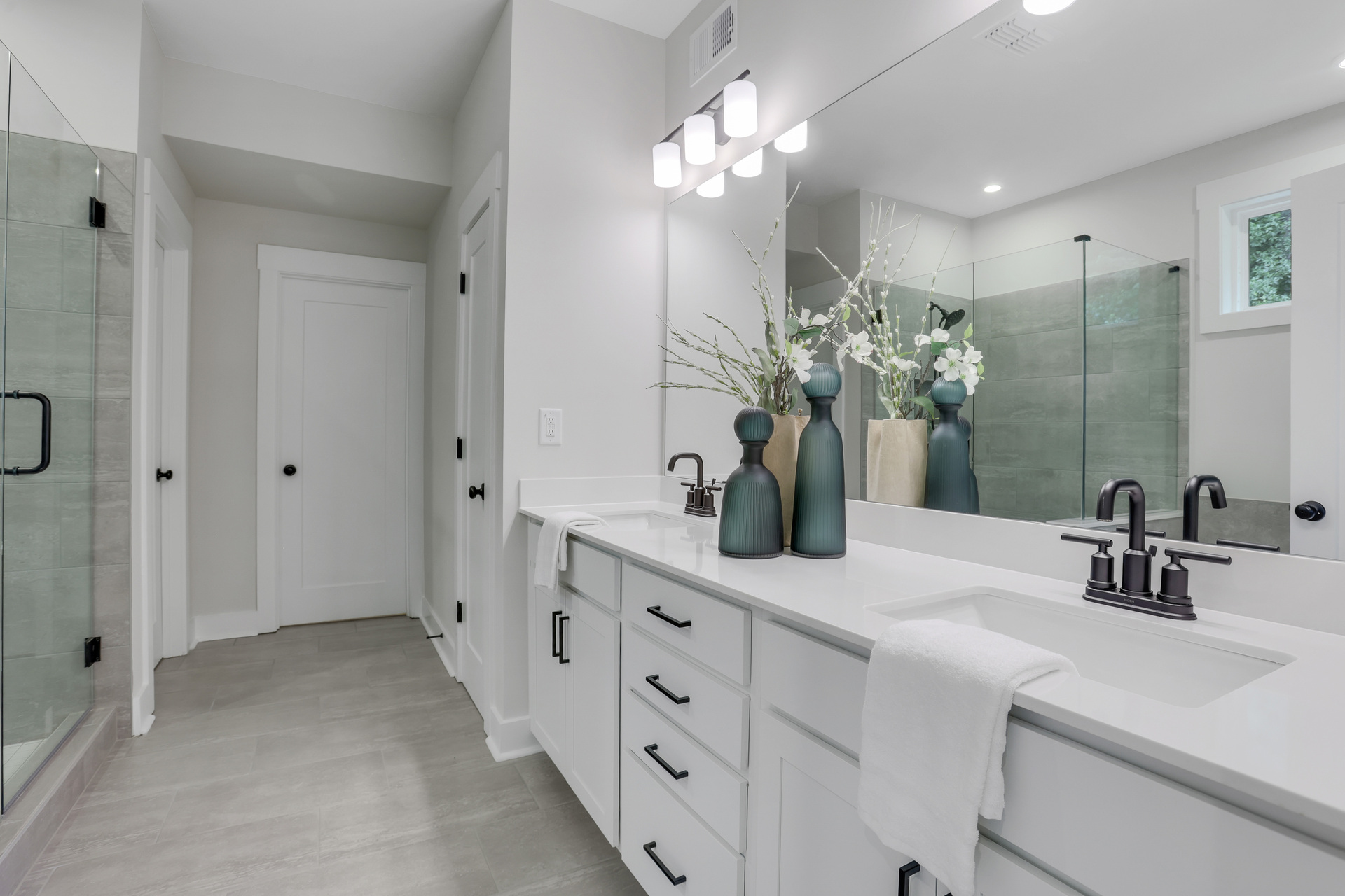 primary bathroom with white cabinets and tile flooring