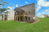 back of 2-story home on a basement with covered deck