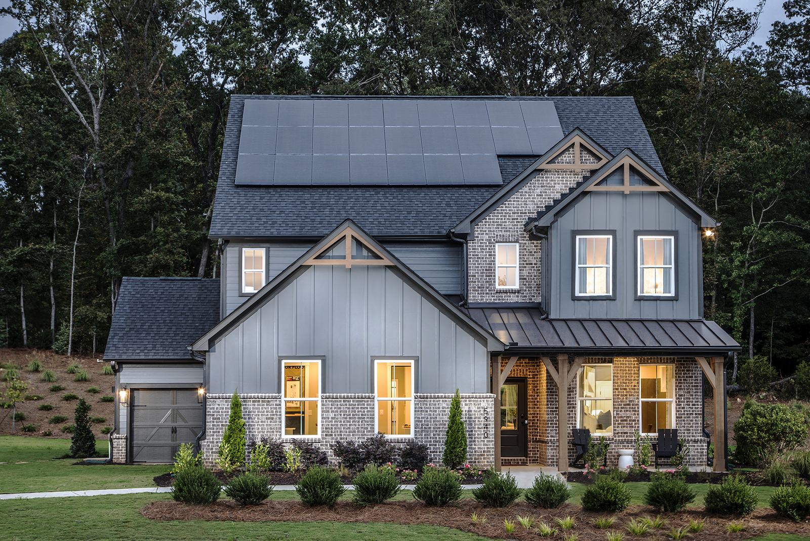 front of 2-story home with dark siding and brick