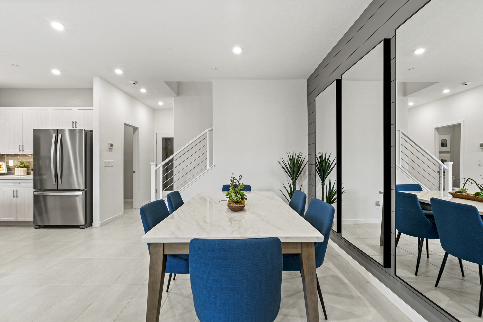 dining room with white table and three big mirrors
