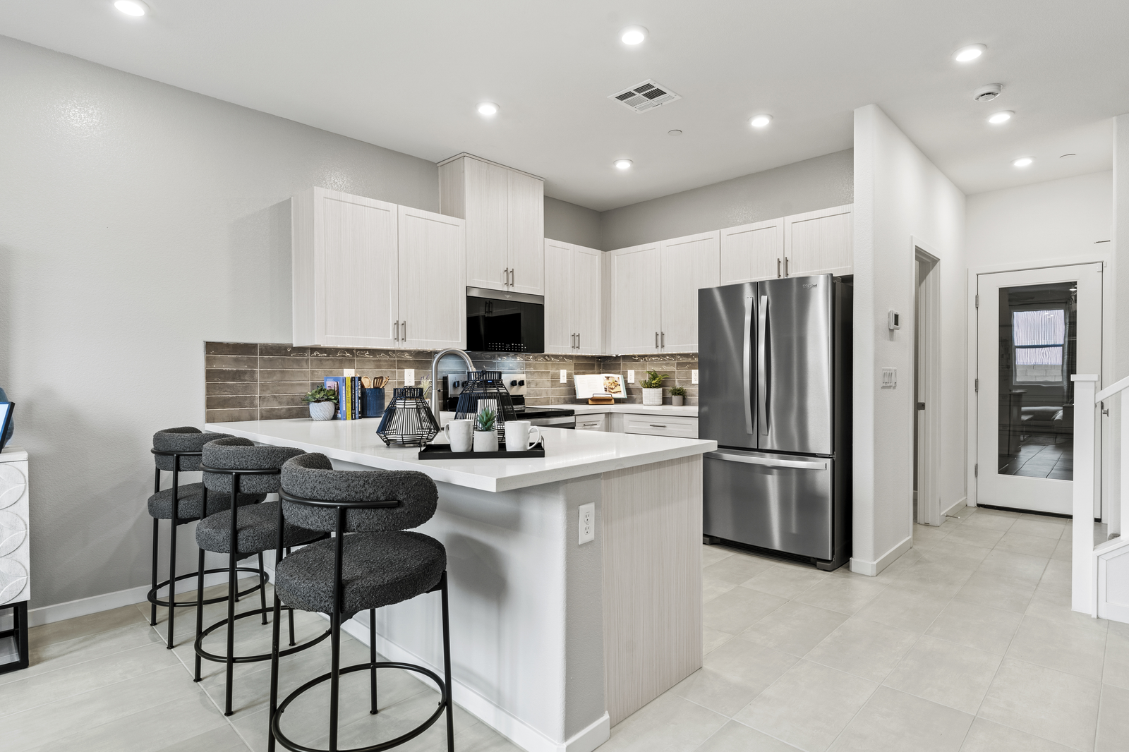 kitchen with grey bar stools and white countertops