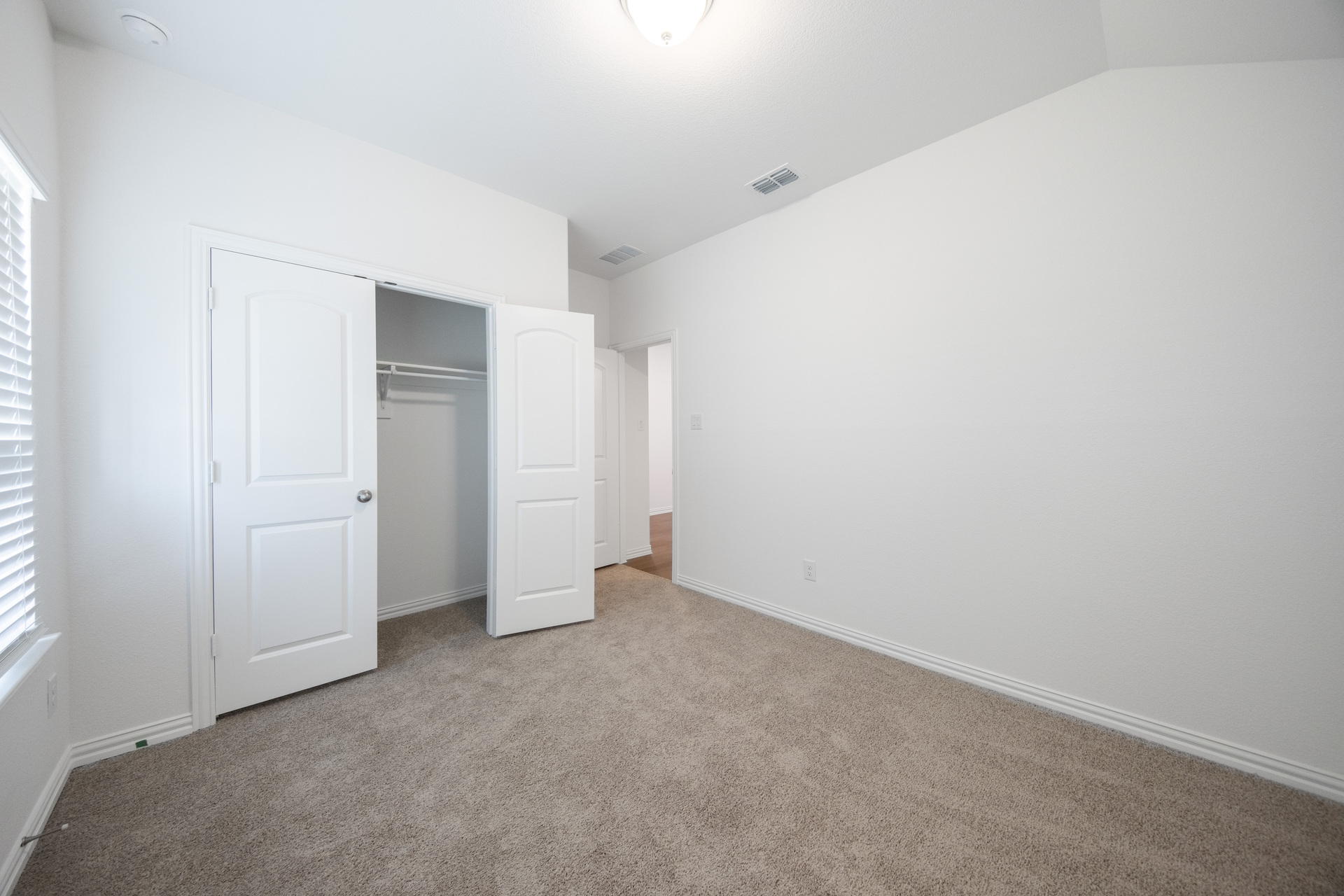 guest bedroom with carpet and window