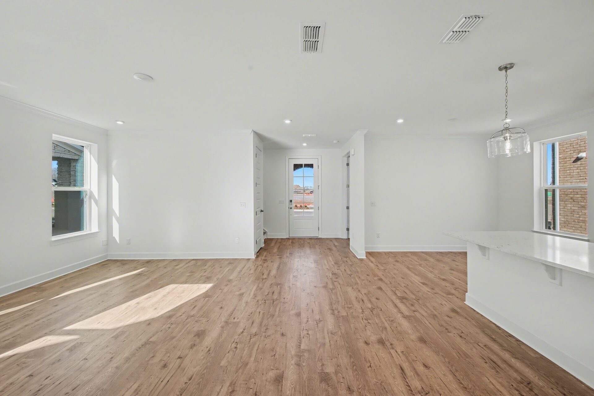 great room with large windows and wood flooring