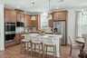 kitchen with wood cabinets, white countertops, stainless steel appliances, barstools, and dining table