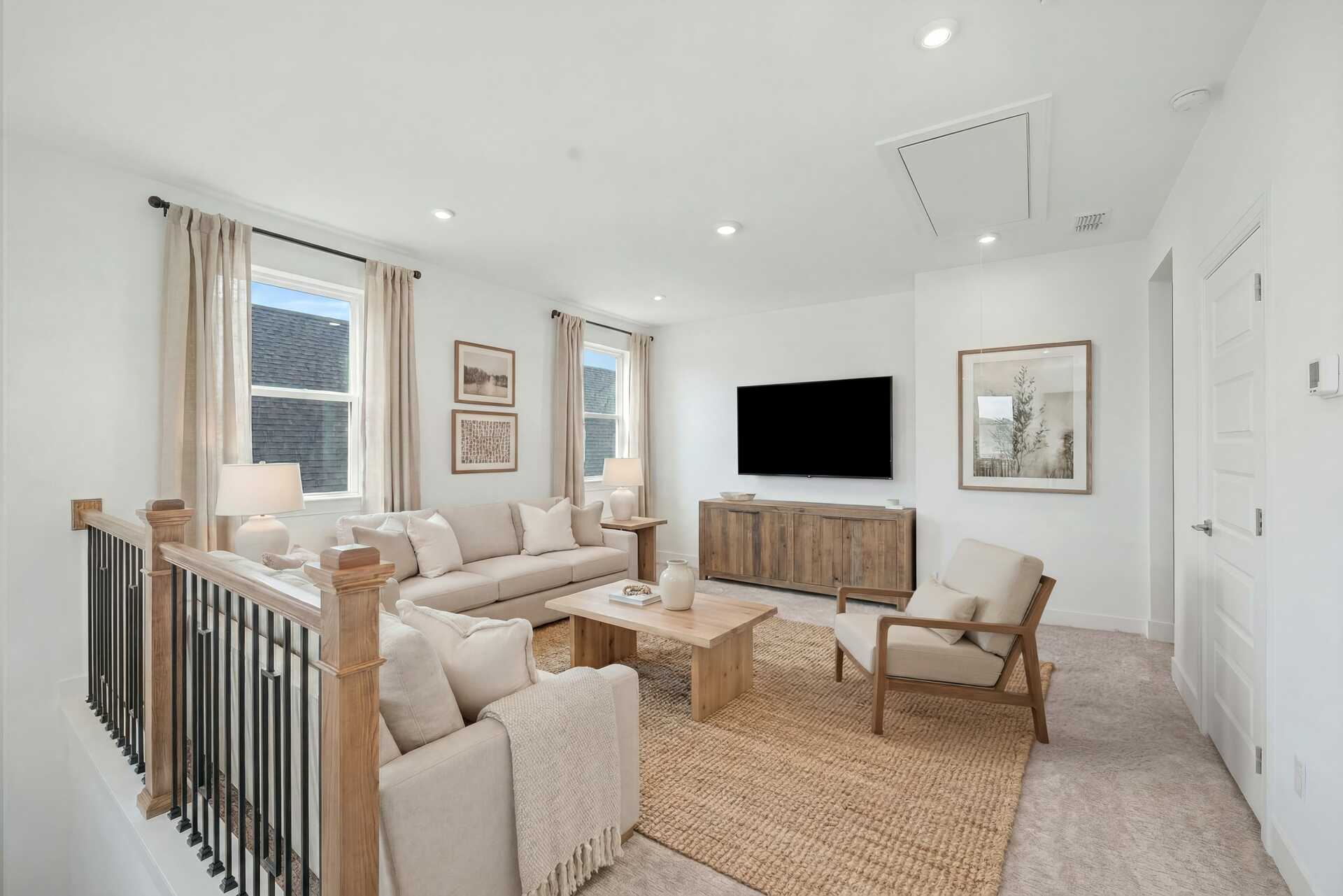 loft space with sofas, accent furniture, a tv, and large windows