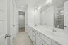 primary bathroom with walk in shower and dual sink vanity