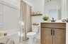 secondary bathroom with wood cabinets, white countertops, and a shower and tub combination