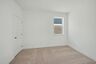 bedroom with carpet, large windows, and walk in closets