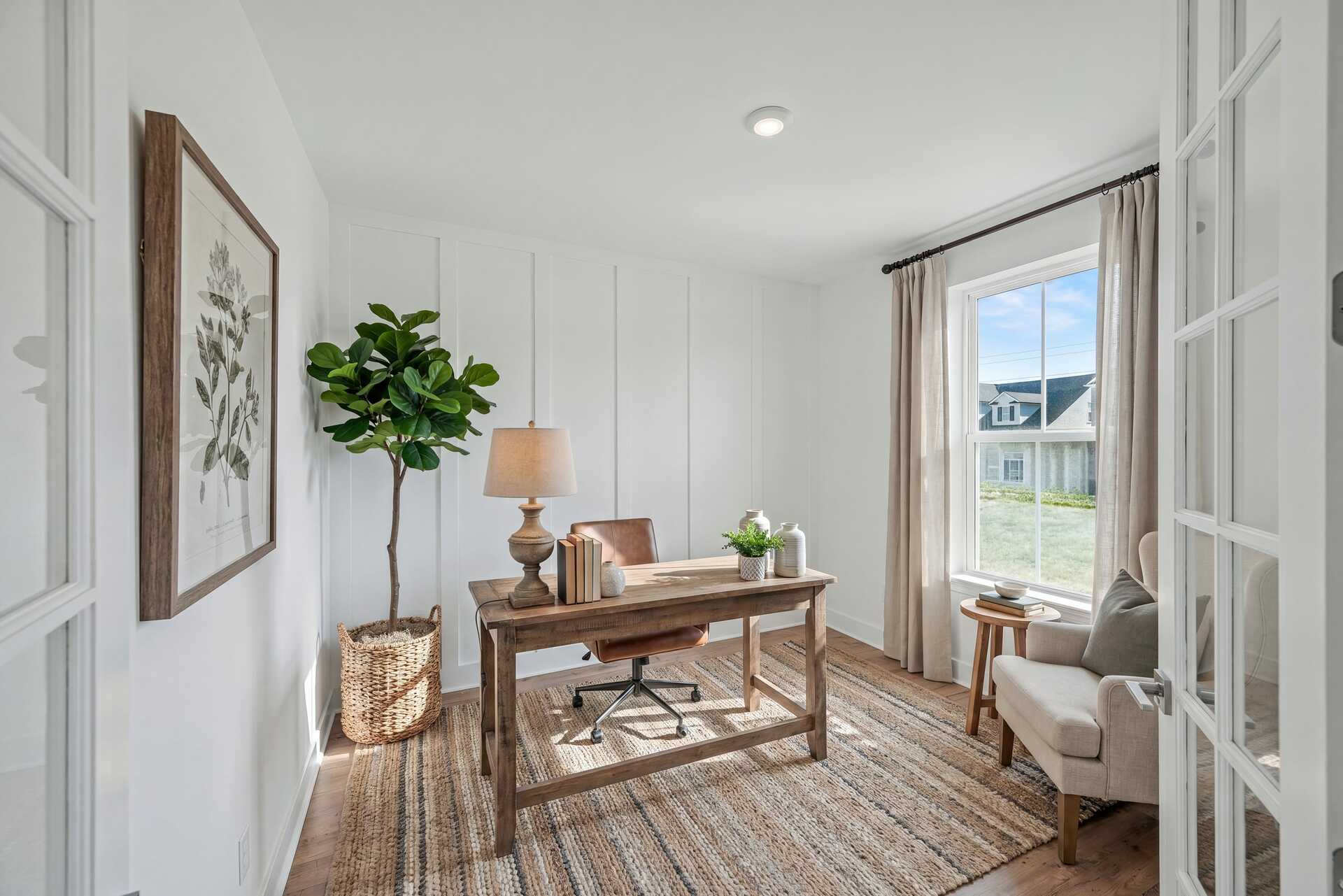 study with wood flooring, accent wall, desk and chair, windows, and curtains
