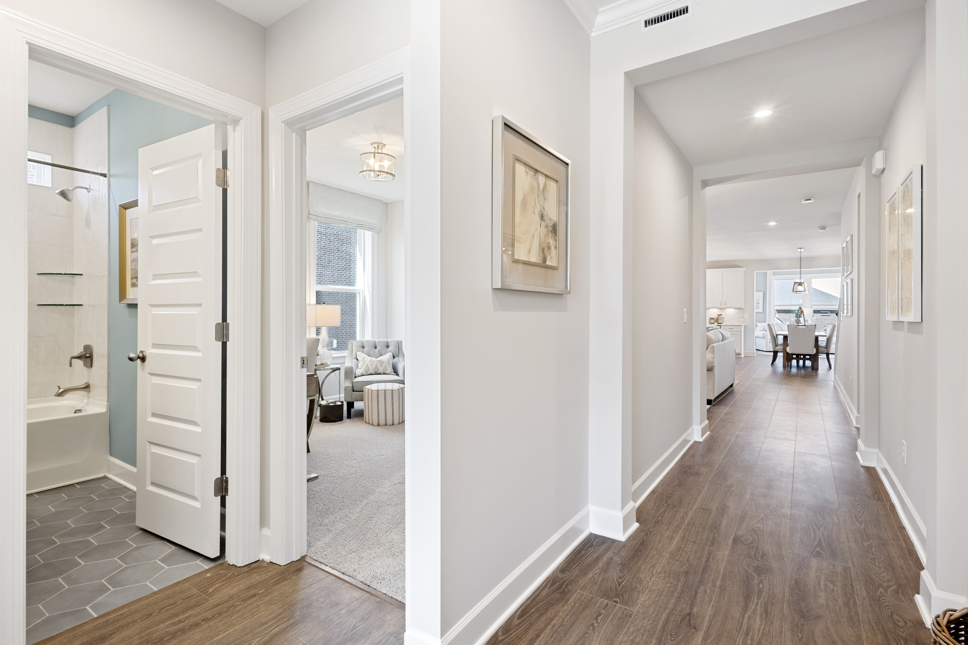entryway with hardwood floor, white walls, bathroom and bedroom off of hallway
