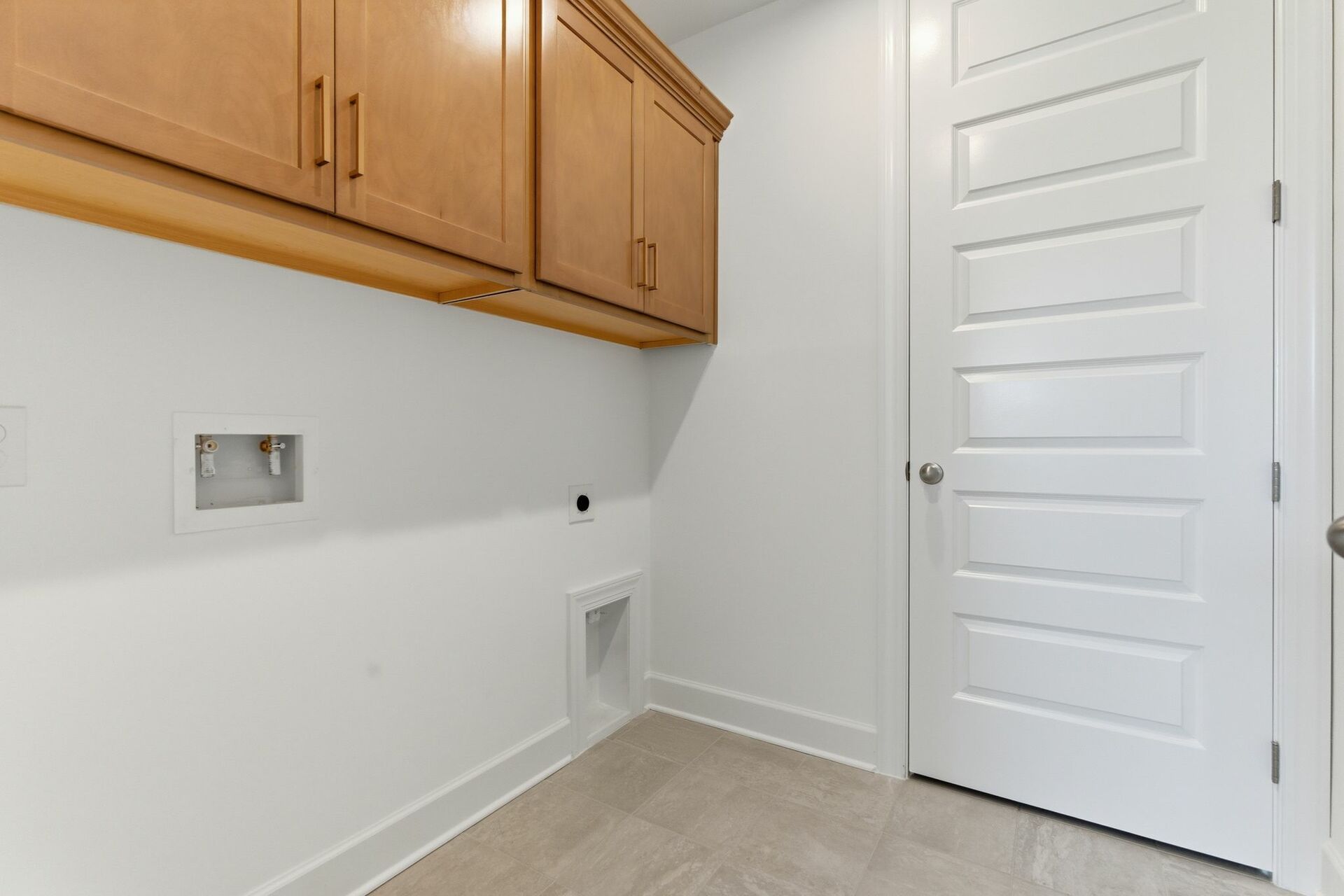 laundry room with wooden cabinet above head storage