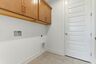 laundry room with wooden cabinet above head storage