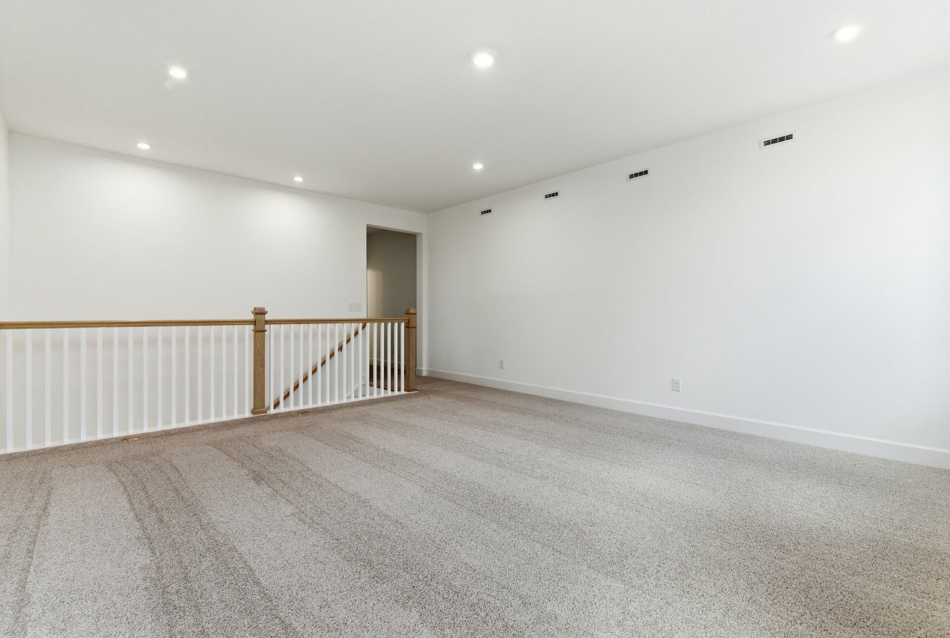 upstairs loft with carpet and large windows
