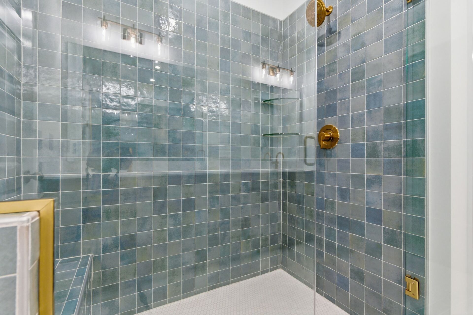 primary bathroom with light pewter blue mosaic shower tile and gold hardware, double sink vanity