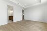 primary bedroom with hardwood floors, large windows, double door walk-in closet, and attached bathroom 