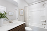 secondary bathroom with tub shower and large mirror