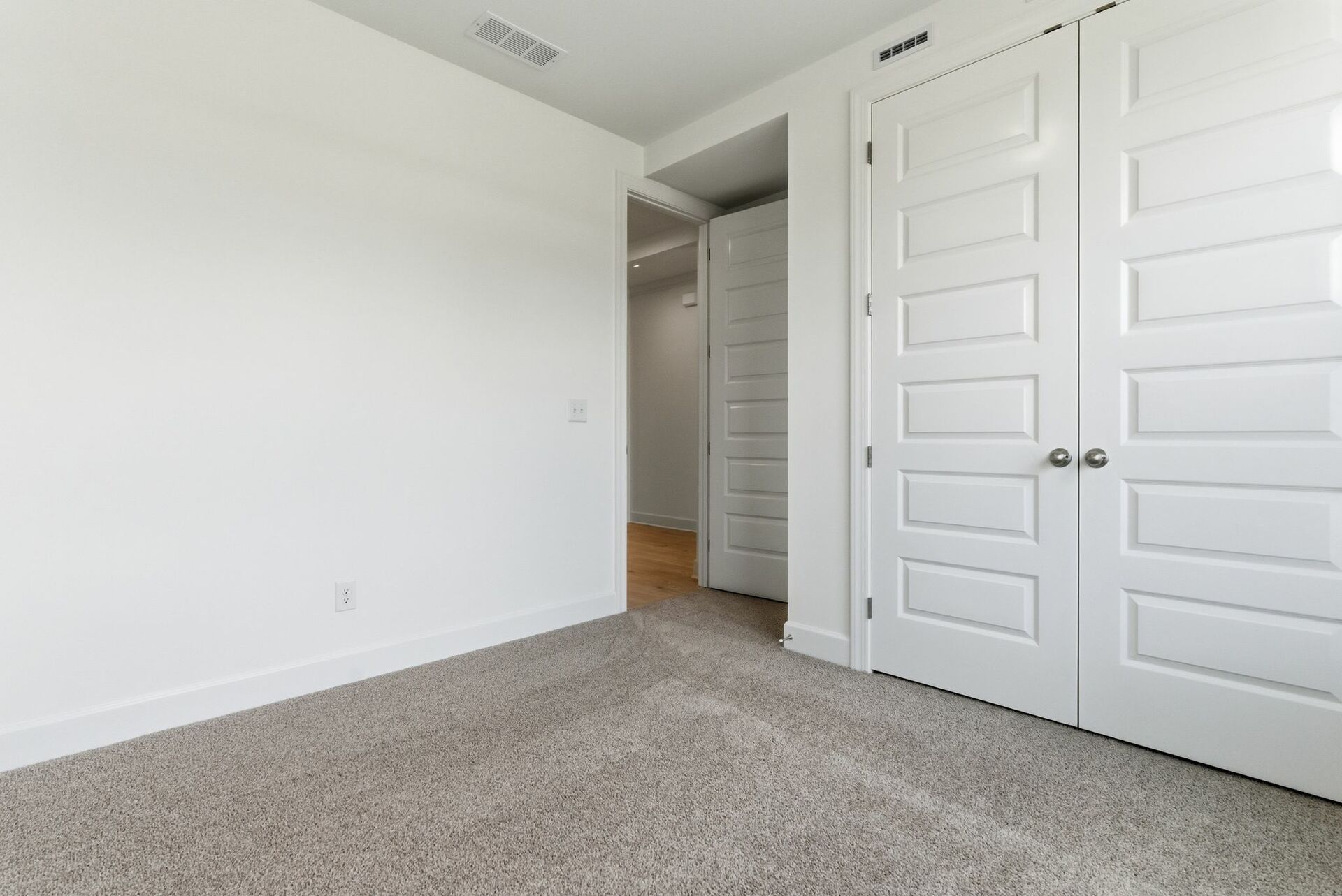 bedroom with light carpet, white walls, and large windows
