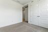 bedroom with light carpet, white walls, and large windows