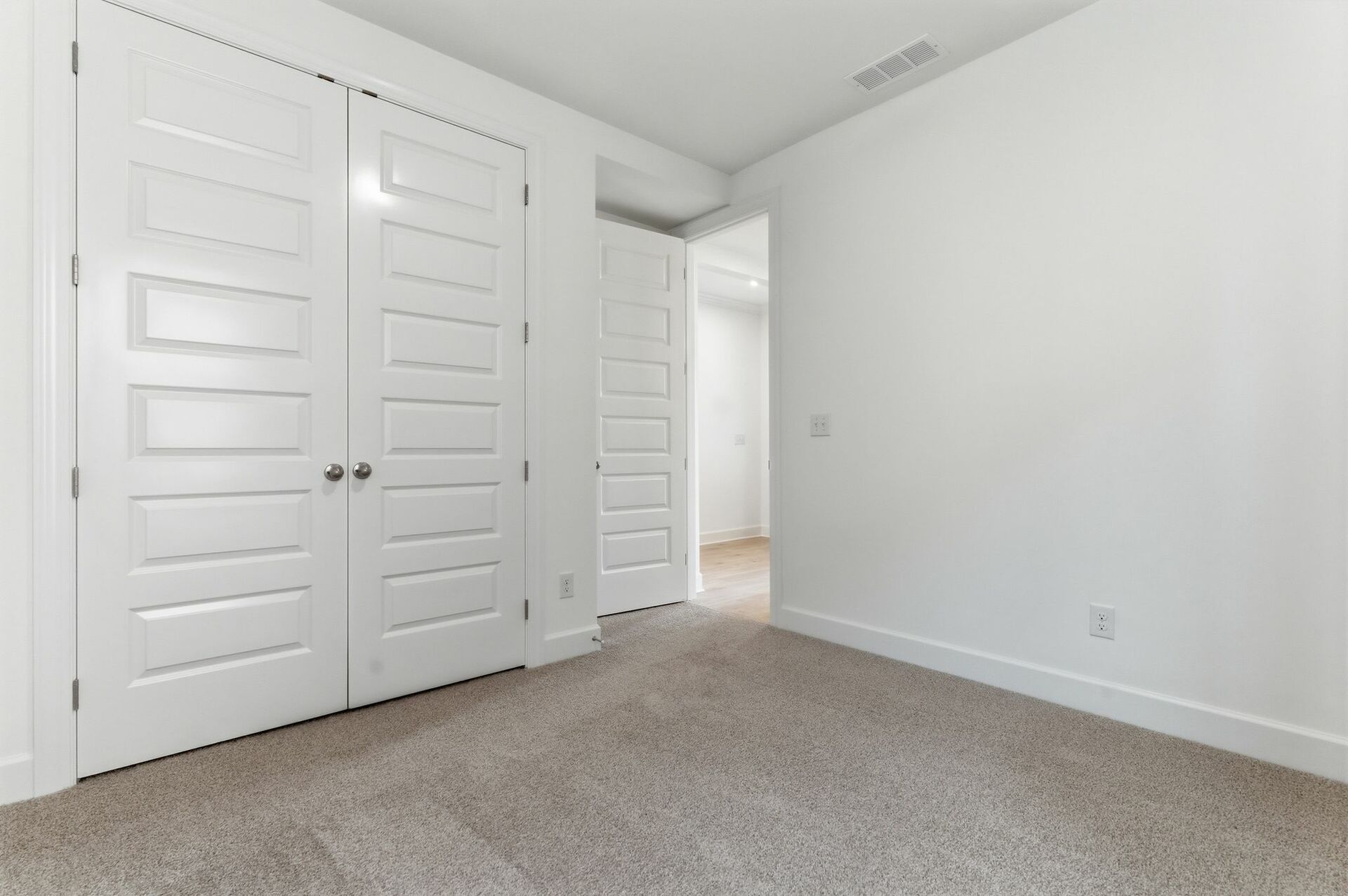 bedroom with light carpet, white walls, and large windows