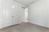 bedroom with light carpet, white walls, and large windows