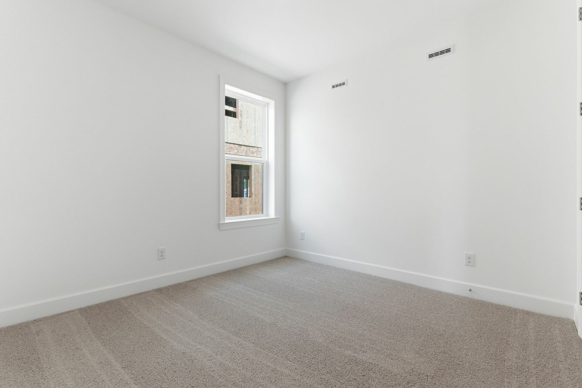 bedroom with light carpet, white walls, and large windows