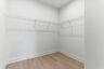 walk in closet with wood floors and built in shelves