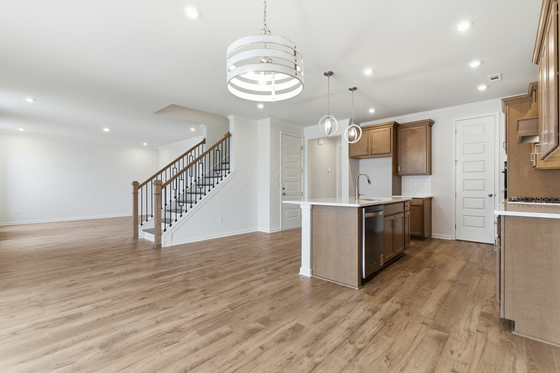 kitchen with wood cabinets, built in microwave and oven, island with sink, and stainless-steel appliances