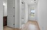 foyer with black entry door with smart lock, white walls and wood floors
