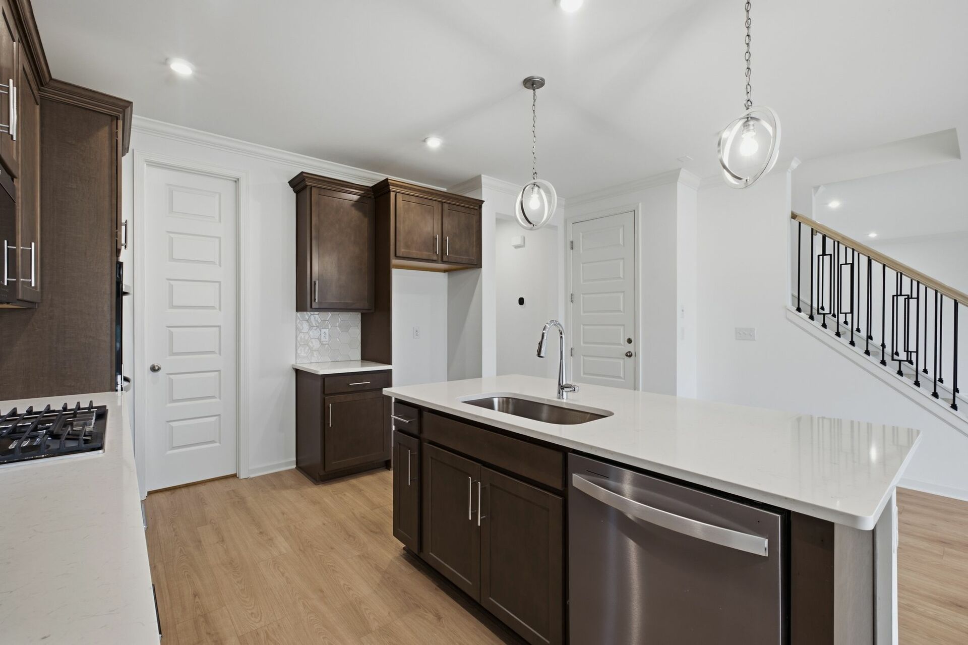 kitchen with dark brown cabinets, large island with sink, gas cooktop and microwave oven combo
