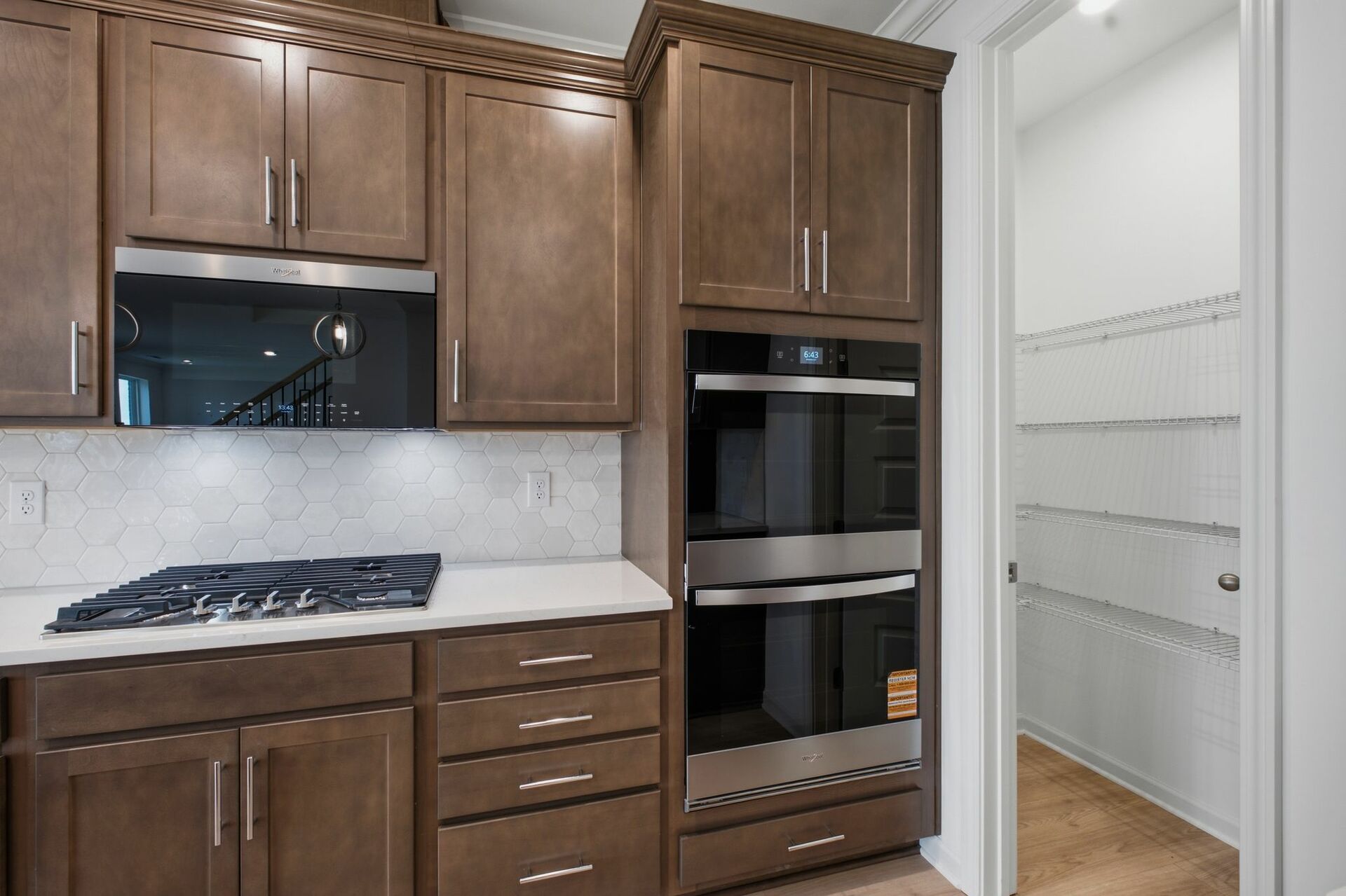 kitchen with dark brown cabinets, large island with sink, gas cooktop and microwave oven combo