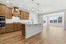 kitchen with wood cabinets, built in microwave and oven, island with sink, and stainless-steel appliances