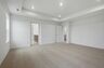 primary bedroom with carpet, large windows, tray ceiling, walk-in closet, and attached bathroom