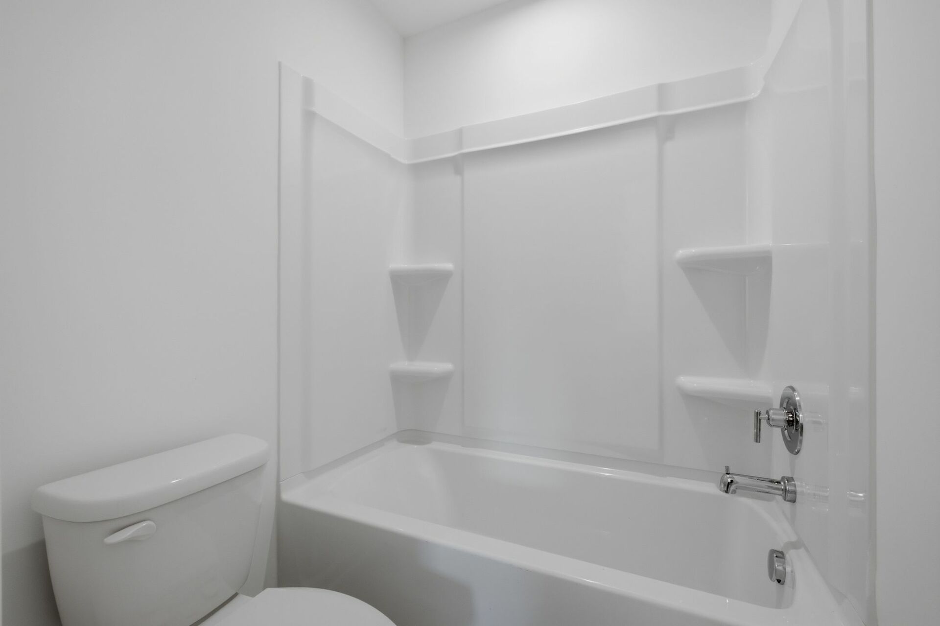 secondary bathroom with double sink vanity and tub with shelves