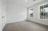 secondary bedroom with carpet, two large windows, and walk in closet