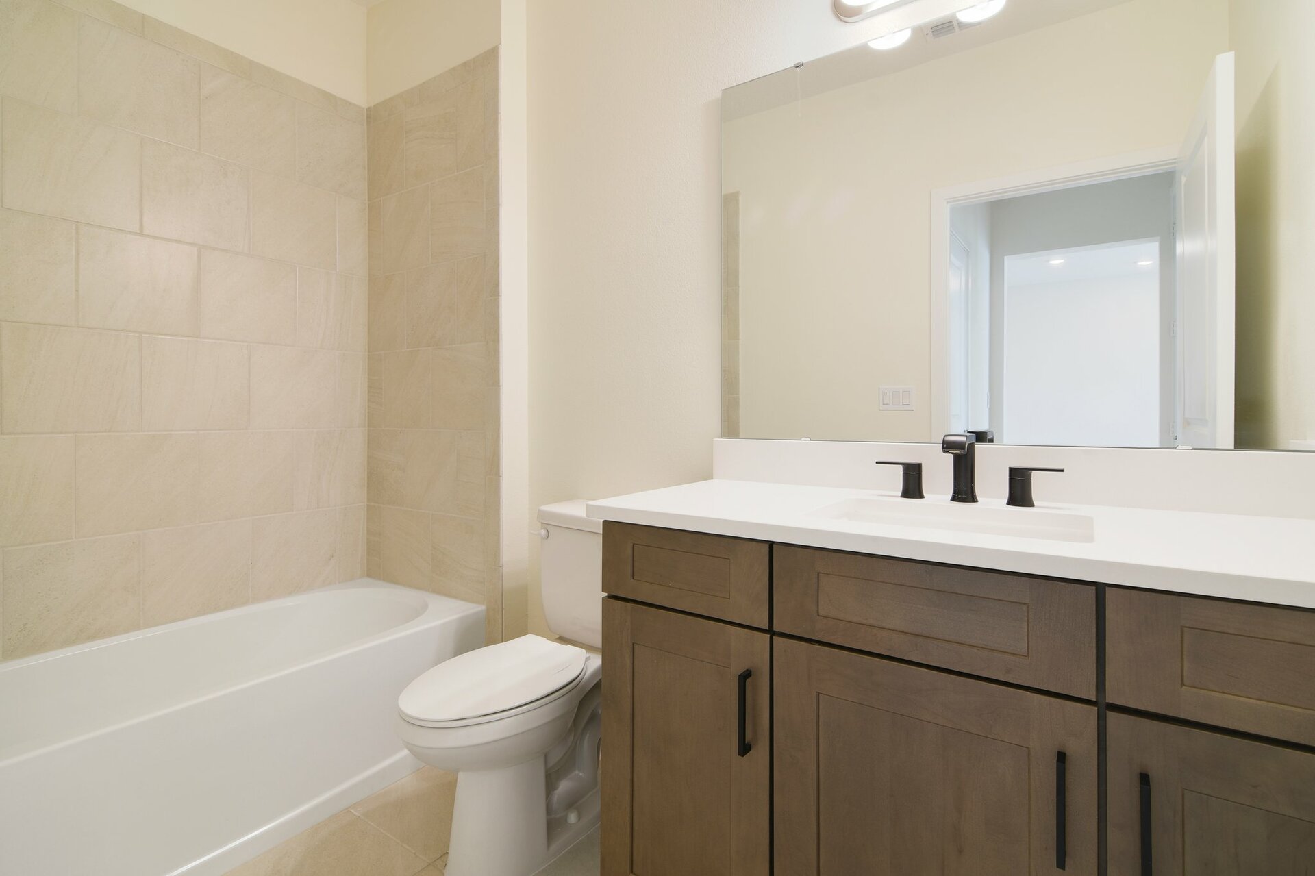 secondary bathroom with brown cabinets, white countertops, and shower and tub combo